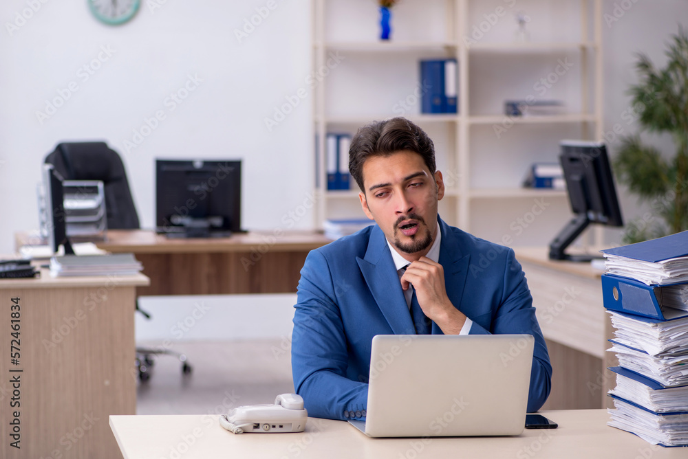 Young businessman employee unhappy with excessive work in the of Young businessman employee unhappy with excessive work in the of