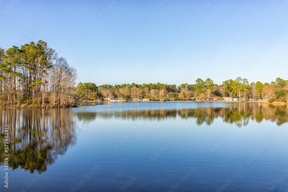 Naklejka premium Eutawville, South Carolina sunset near Lake Marion with waterfront houses and docks water landscape view at Fountain lake in spring evening with nobody and pine trees