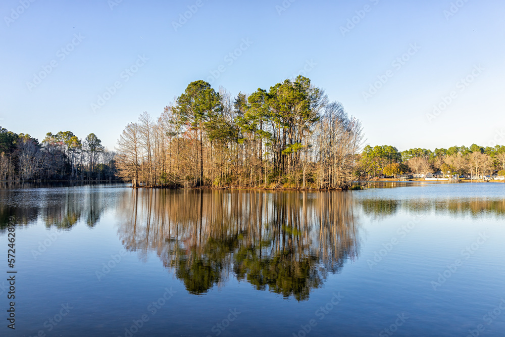 Eutawville, South Carolina sunset in town near Lake Marion with water landscape view at Fountain lake in spring evening with nobody and pine trees Eutawville, South Carolina sunset in town near Lake Marion with water landscape view at Fountain lake in spring evening with nobody and pine trees