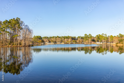 Fototapeta Naklejka Na Ścianę i Meble -  Eutawville, South Carolina sunset near Lake Marion with waterfront houses and docks water landscape view at Fountain lake in spring evening with nobody and pine trees