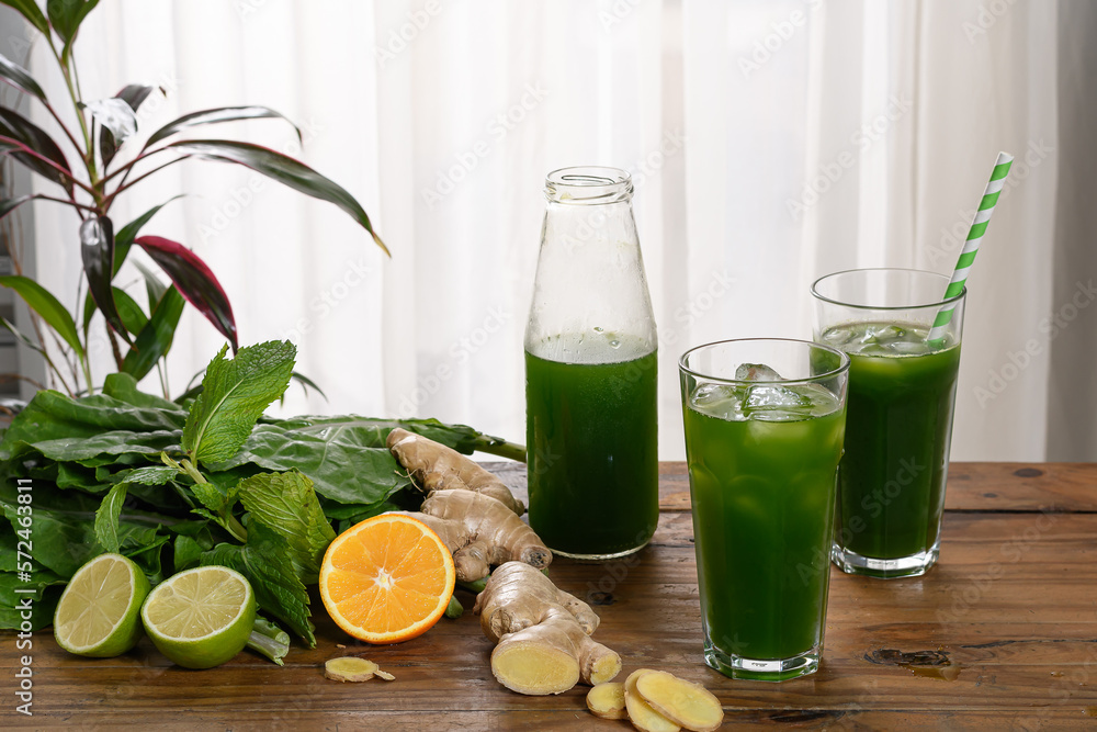 detox green juice, glass with green juice on a wooden board, small fruit ingredient for the juice next to the glass with the drink detox green juice, glass with green juice on a wooden board, small fruit ingredient for the juice next to the glass with the drink