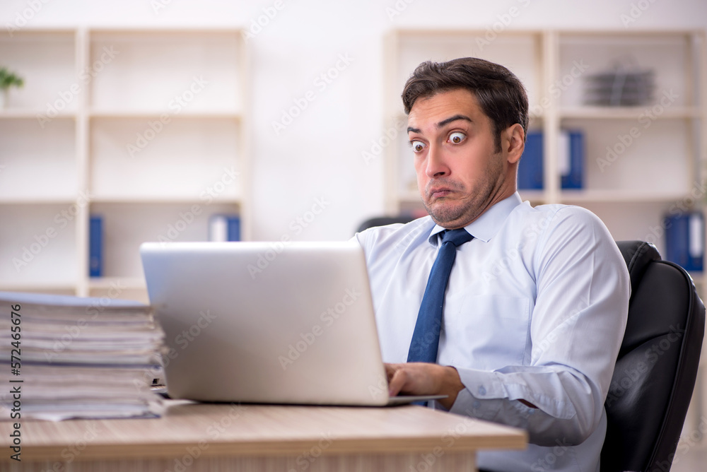 Young male employee working in the office Young male employee working in the office