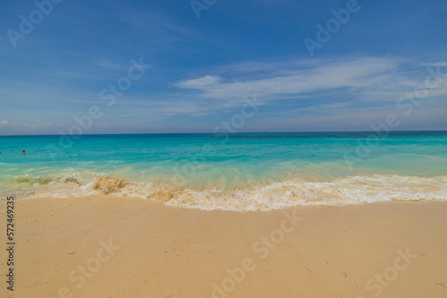 Beautiful view of turquoise water of Atlantic Ocean with rolling waves on sandy beach of Eagle Beach. Aruba island.
