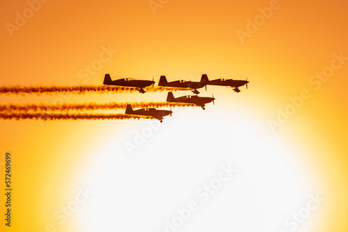 Five plane flying in formation at an airshow at dusk