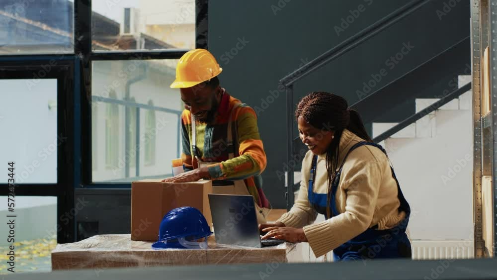 Team of workers using racks and shelves to stack boxes, packing merchandise before shipment. Man and woman laughing at work, doing quality control and logistics before transportation. Team of workers using racks and shelves to stack boxes, packing merchandise before shipment. Man and woman laughing at work, doing quality control and logistics before transportation.