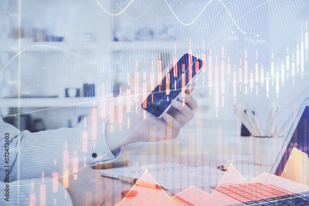 Double exposure of man's hands holding and using a digital device and forex graph drawing. Financial market concept. Double exposure of man's hands holding and using a digital device and forex graph drawing. Financial market concept.
