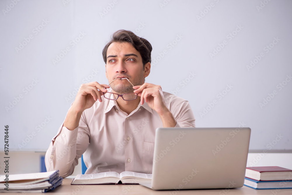 Young male teacher student sitting in the classroom Young male teacher student sitting in the classroom