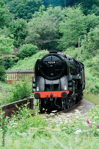 Steam train carrying carriages traveling in the North Yorkshire Moors. Passing through Goathland station  made famous by Harry Potter movies  United Kingdom.