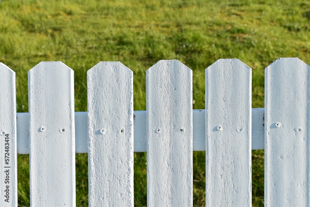 White picket fence with green grass. White picket fence with green grass.