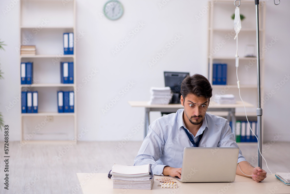 Young male employee suffering at workplace Young male employee suffering at workplace