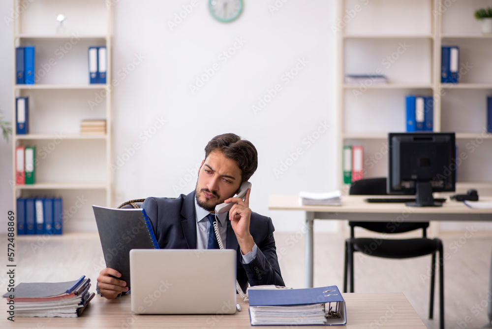 Young male employee working in the office Young male employee working in the office