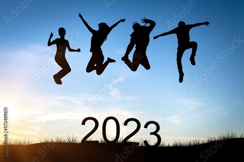 Happy people group jump with 2023 numbers.