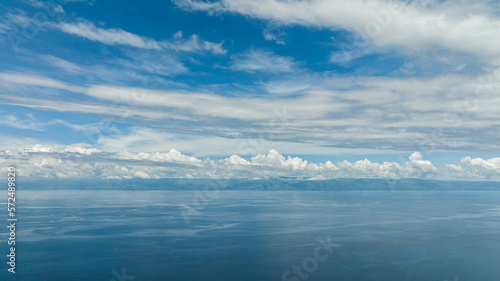 Top view of the island of Cebu from the sea. Blue ocean and sky with clouds. Seascape in the tropics.