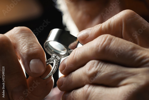 Professional jeweler working with ring, closeup view photo
