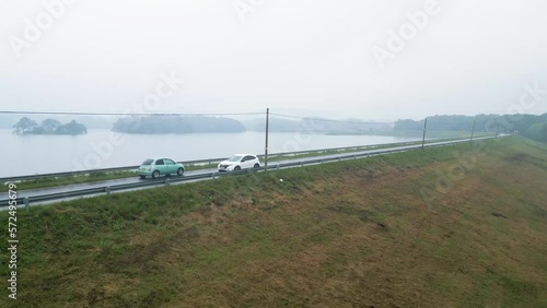 Cars through a road in Loggal Oya reservoir on a rainy day. Sri Lanka. Aerial view photo