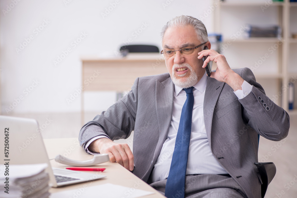 Old male employee working in the office Old male employee working in the office