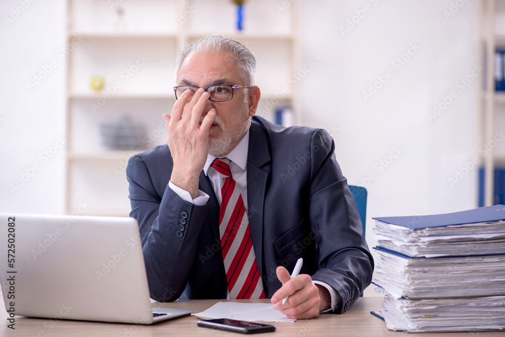 Old male employee and too much work in the office Old male employee and too much work in the office