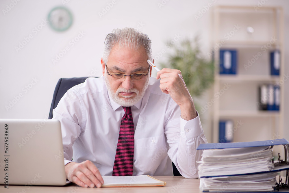 Old male employee and too much work in the office Old male employee and too much work in the office