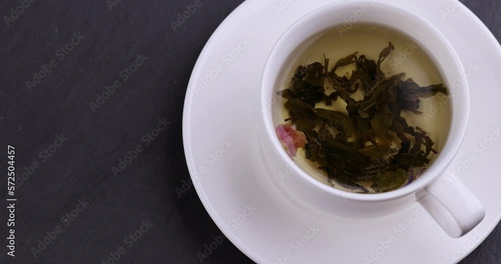 Brewed strong green tea in a white porcelain cup Brewed strong green tea in a white porcelain cup
