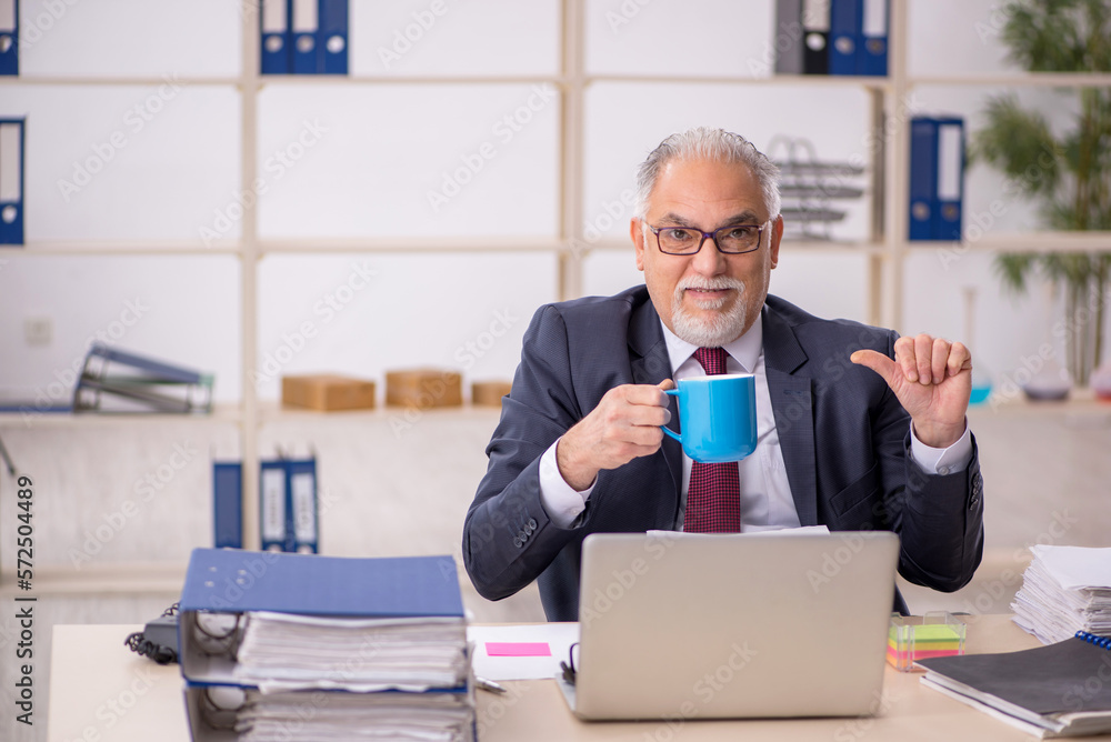 Old male employee drinking coffee during break Old male employee drinking coffee during break