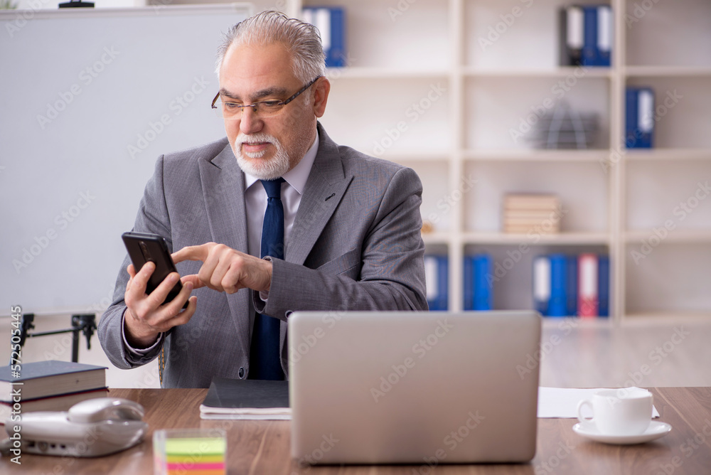 Old male employee working in the office Old male employee working in the office
