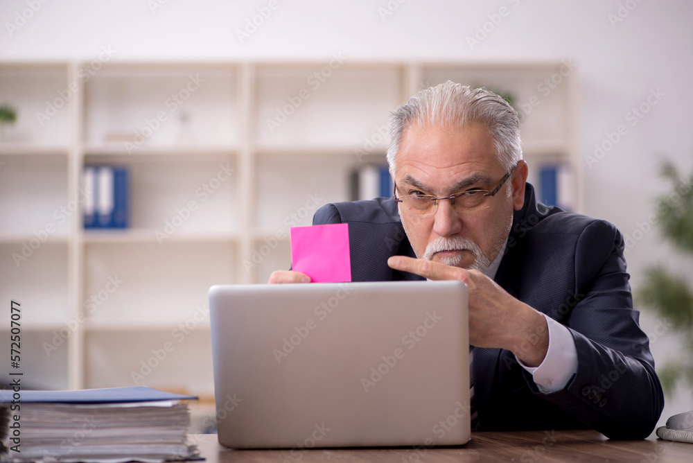 Old male employee working in the office Old male employee working in the office