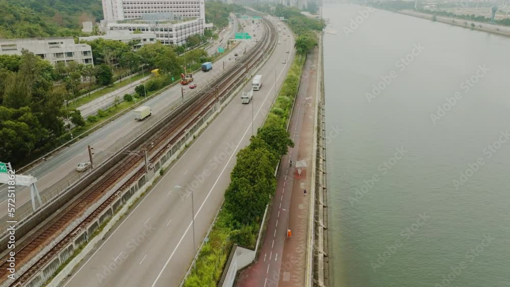 Drone shot panning forwards over a busy highway next to a river on a gray foggy day Drone shot panning forwards over a busy highway next to a river on a gray foggy day