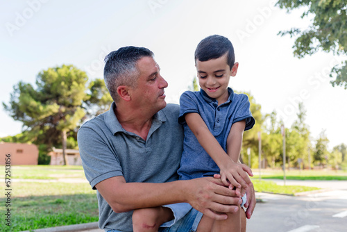Father and son spending time together outdoors in a park. © Viviland