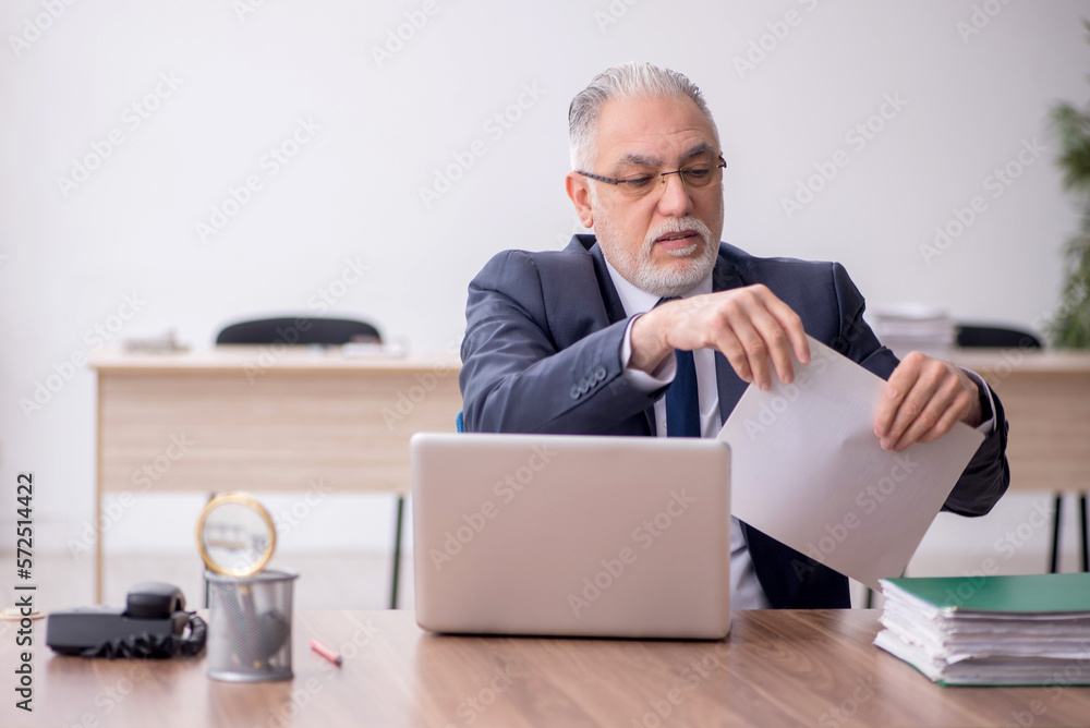 Old male employee working in the office Old male employee working in the office
