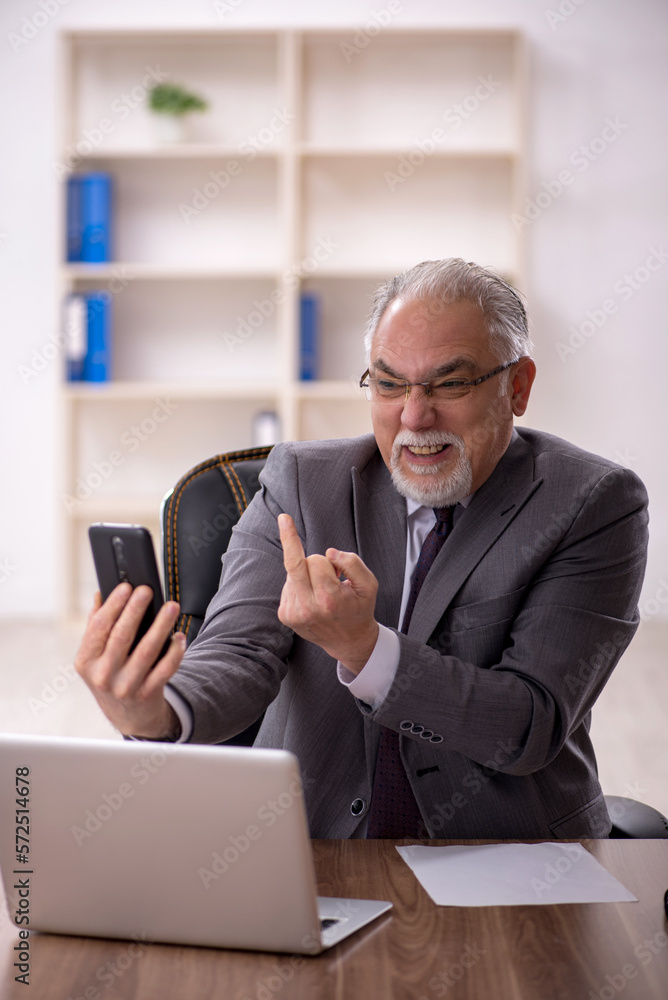 Old male employee working in the office Old male employee working in the office