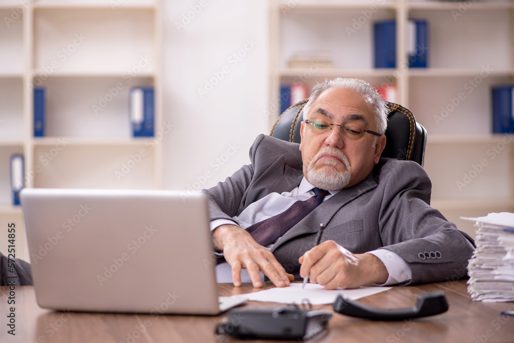 Old male employee working in the office Old male employee working in the office