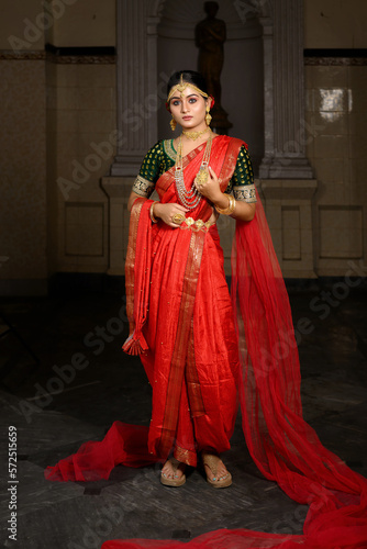 Slika na platnu Portrait of beautiful young Indian lady in luxurious costume with makeup and heavy jewellery posing fashionable in front of a vintage background
