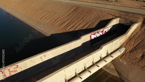 Aerial flyover of a graffiti covered bridge over an aqueduct in the high desert, Hesperia, California in morning light and dramatic shadows photo