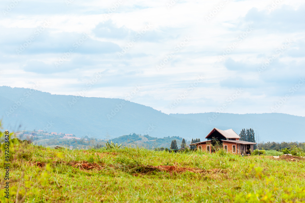 Alone small house in valley among green trees and mountains on background Alone small house in valley among green trees and mountains on background