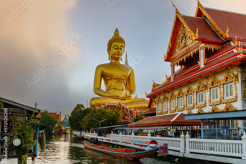 Big Buddha (Wat Paknam) at sunset. Chao Phraya river canal cruise. Tourists traveling by traditional boats. Thailand's most important travel destinations. Bangkok, Thailand

