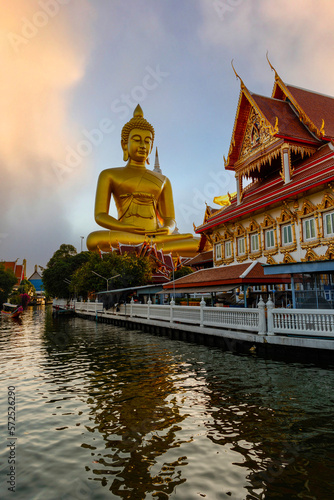 Big Buddha statue at Wat Paknam Phazi Charoen, viewed from the canal at sunset © dron285