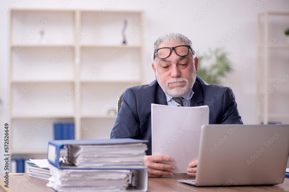 Old male employee and too much work at workplace Old male employee and too much work at workplace