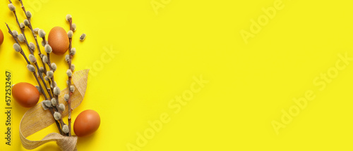 Photography Pussy willow branches and eggs on yellow background with space for text