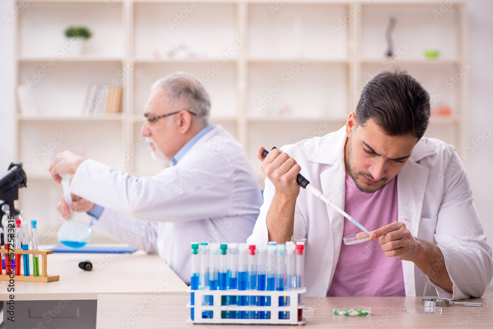 Two male chemists working at the lab Two male chemists working at the lab