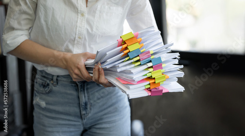 Photos Cropped shot of young female officer holding a pile of paperwork.