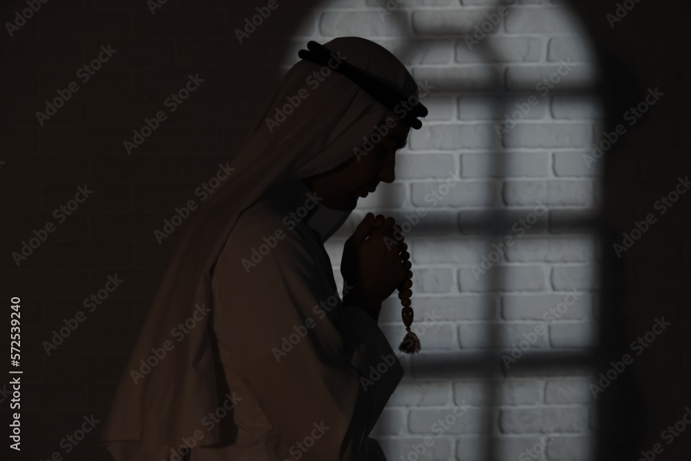 Naklejka premium Praying Muslim man in dark room