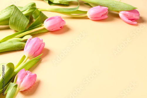 Fototapeta Naklejka Na Ścianę i Meble -  Frame made of beautiful tulip flowers on beige background