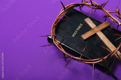 Holy Bible with wooden cross and crown of thorns on purple background. Good Friday concept