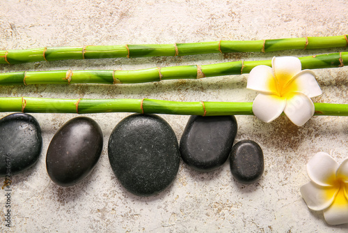 Spa stones  flowers and bamboo on light background  top view