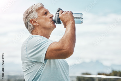 Fotografie Senior man, fitness and drinking water for hydration or thirst after workout, exercise or training in nature