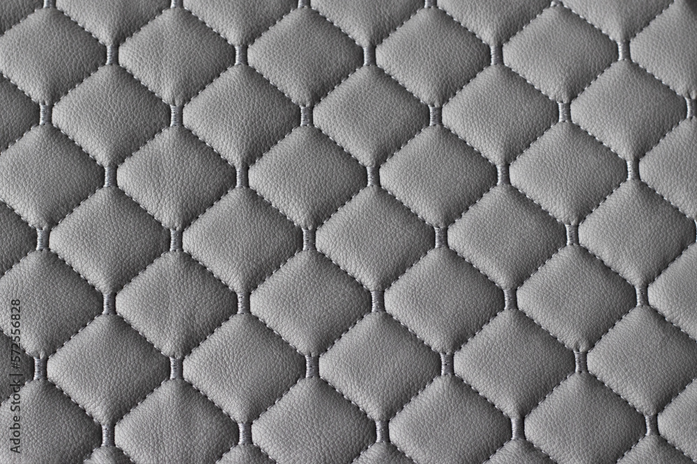 Fototapeta premium Quilted fabric pattern. The texture of the sofa is gray eco leather. Decorative background.