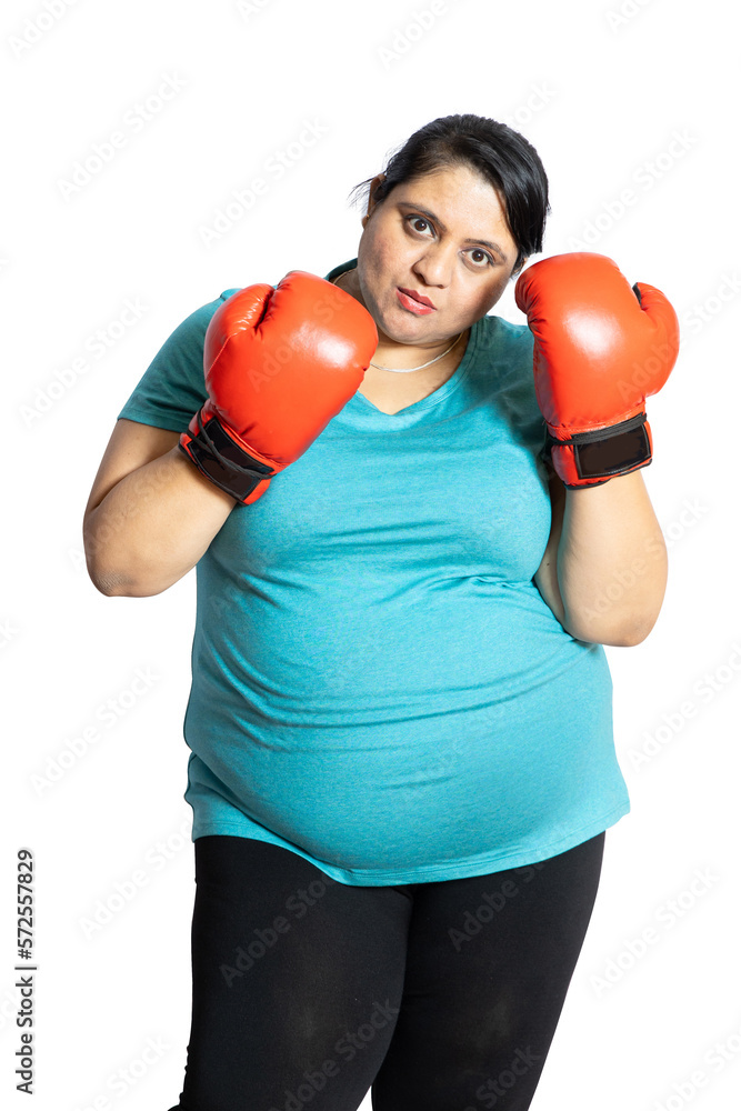Angry Overweight indian woman wearing red boxing gloves ready to fight isolated over white background, Plus size sporty asian female with fighting gesture. Challenge and competition, Closeup.