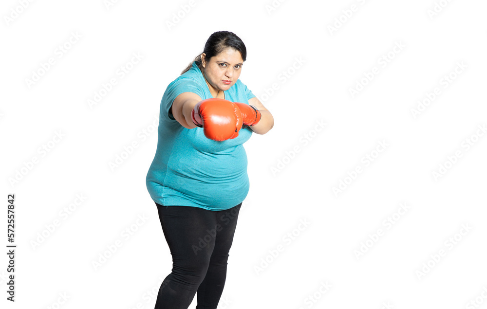 Angry Overweight indian woman wearing red boxing gloves punching isolated over white background, Plus size sporty asian female with fighting gesture.Copy space. Weight loss and healthcare concept. Angry Overweight indian woman wearing red boxing gloves punching isolated over white background, Plus size sporty asian female with fighting gesture.Copy space. Weight loss and healthcare concept.