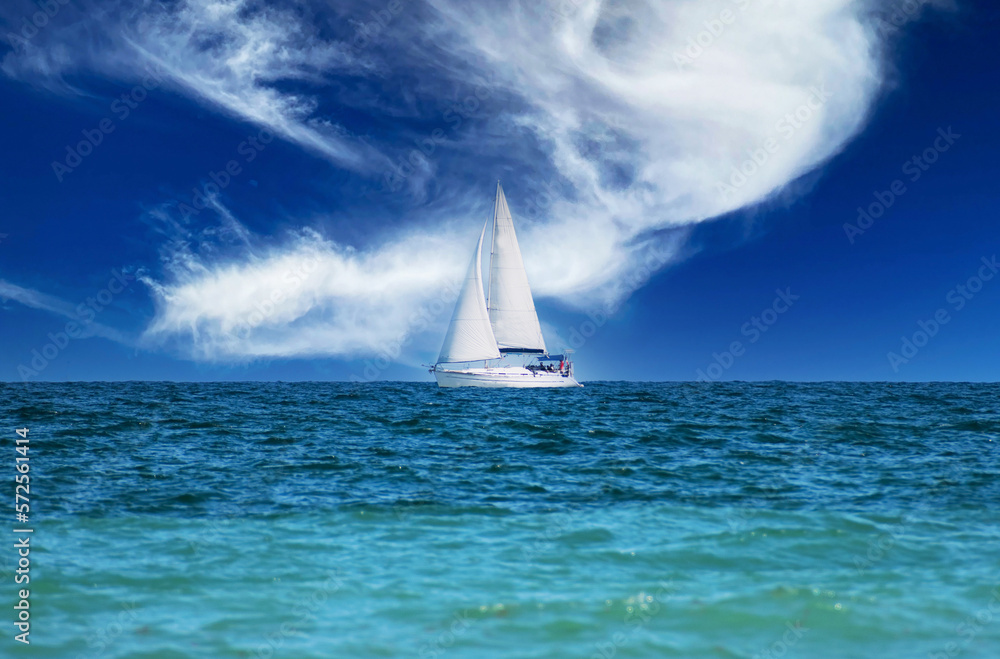 Sailboat on the horizon. Sailboat on the waves of the sea. Fabulous sky in the background.