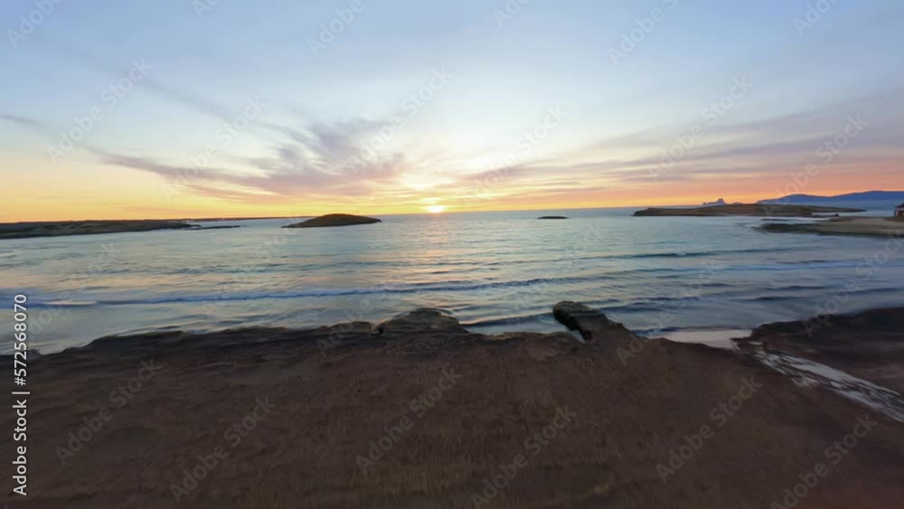 FPV aerial view flying along a dock over the sand dunes and taking off over the sea as the sun sets. FPV aerial view flying along a dock over the sand dunes and taking off over the sea as the sun sets.